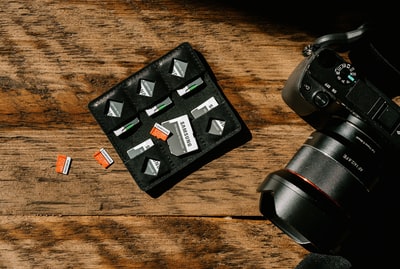 黑色皮革双褶棕色木桌子上的钱包
